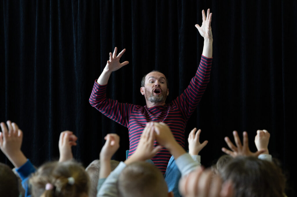 Tony Havart, racontant une histoire avec les enfants participants à l'histoire
